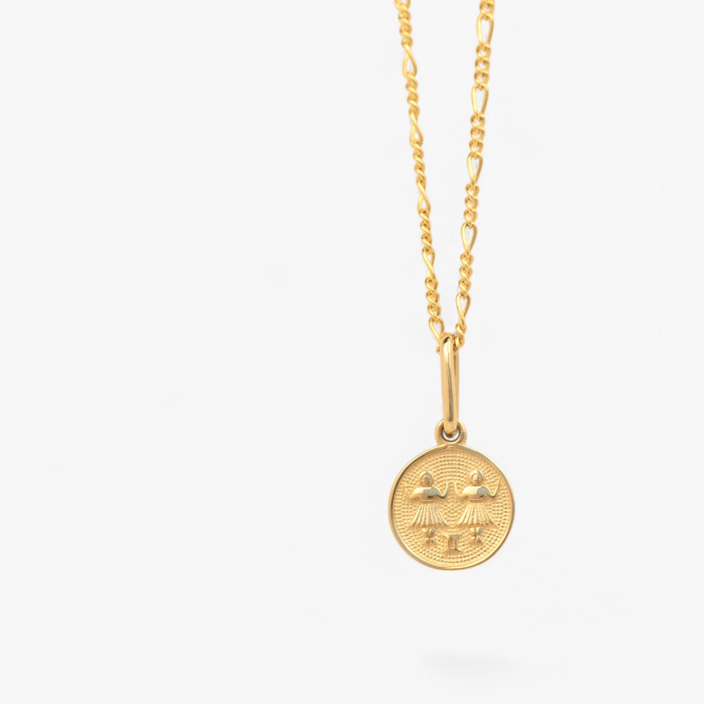 Pandantiv cu zodia gemeni din aur de 14k pe lant din aur de 14k pe fundal alb. 14k solid gold Gemini zodiac charm on a 14k solid gold necklace on a white background