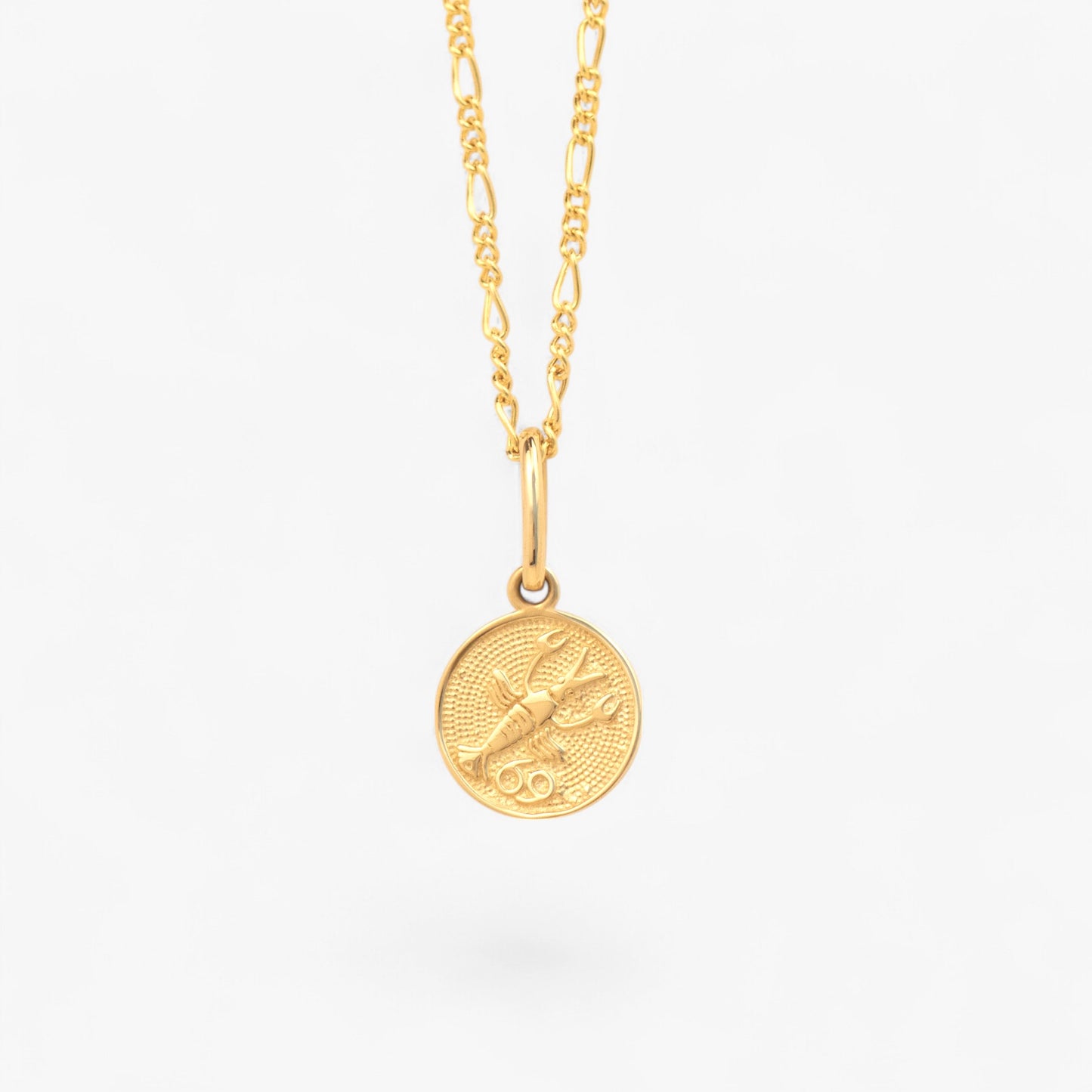 Pandantiv cu zodia Rac din aur de 14k pe lant din aur de 14k pe fundal alb. 14k solid gold Cancer zodiac charm on a 14k solid gold necklace on a white background