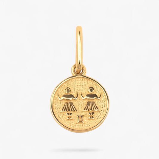 Pandantiv cu zodia gemeni din aur de 14k pe fundal alb. 14k solid gold 
Gemini zodiac charm on a white background