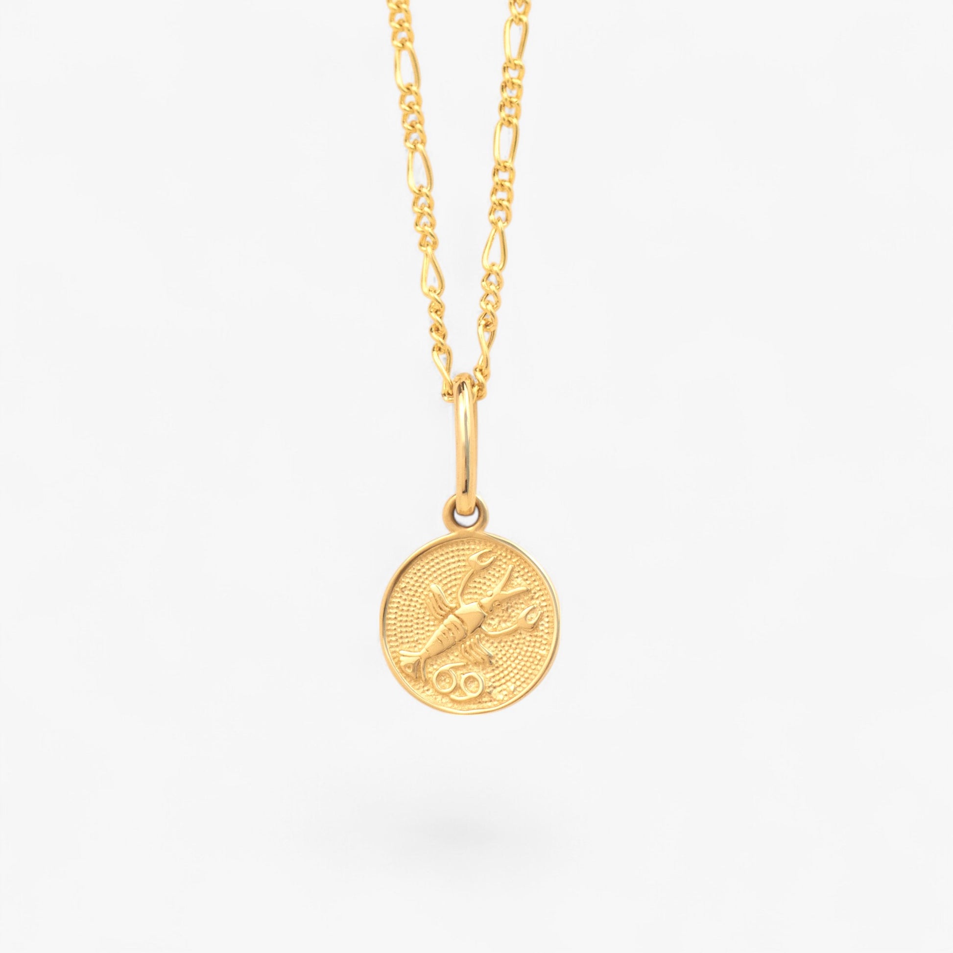 Pandantiv cu zodia Rac din aur de 14k  pe lant din aur de 14k pe fundal alb. 14k solid gold Cancer zodiac charm  on a 14k solid gold necklace on a white background